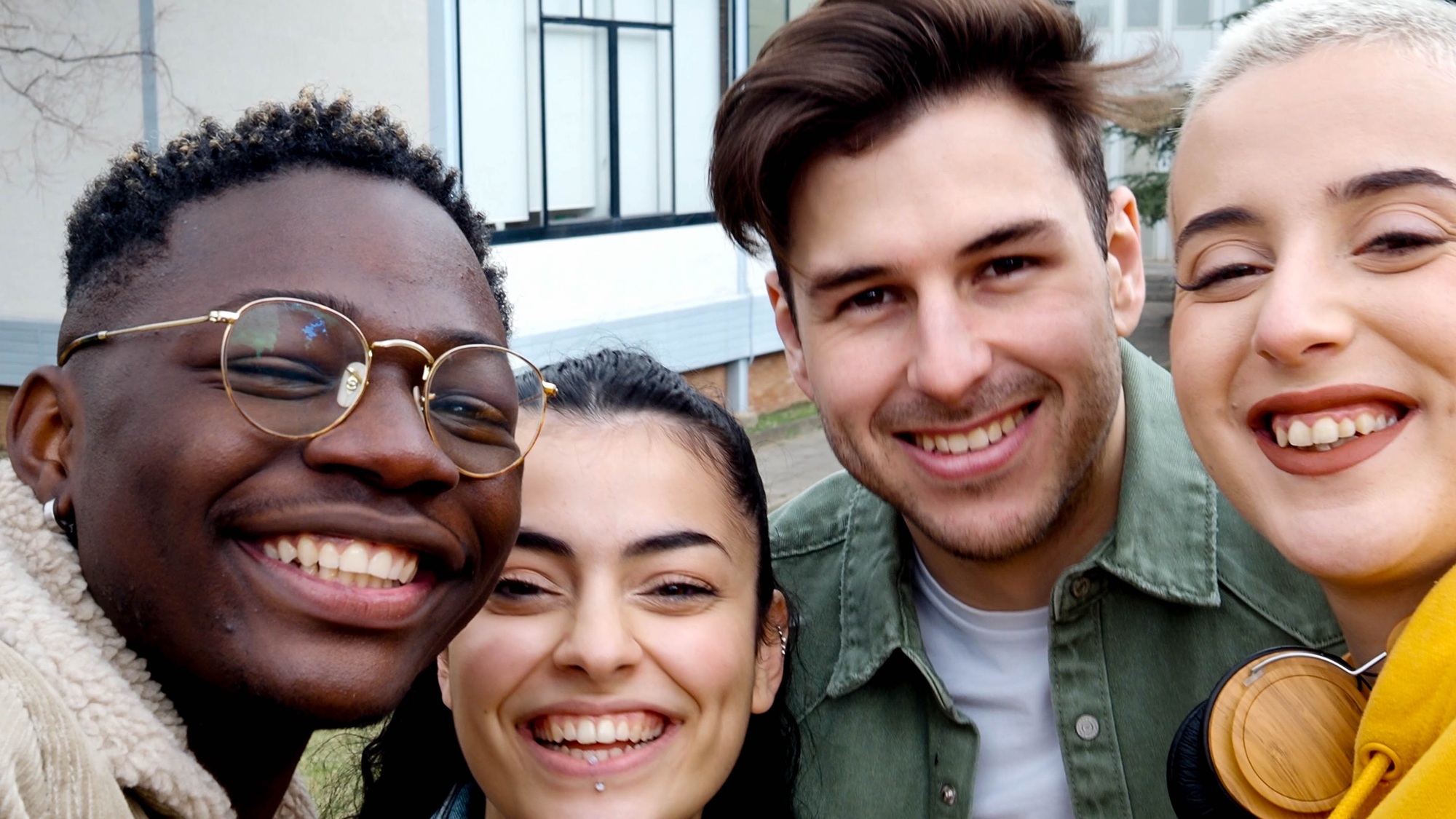 Diverse young student friends having fun on campus. Selfie perspective, college kids, millennials