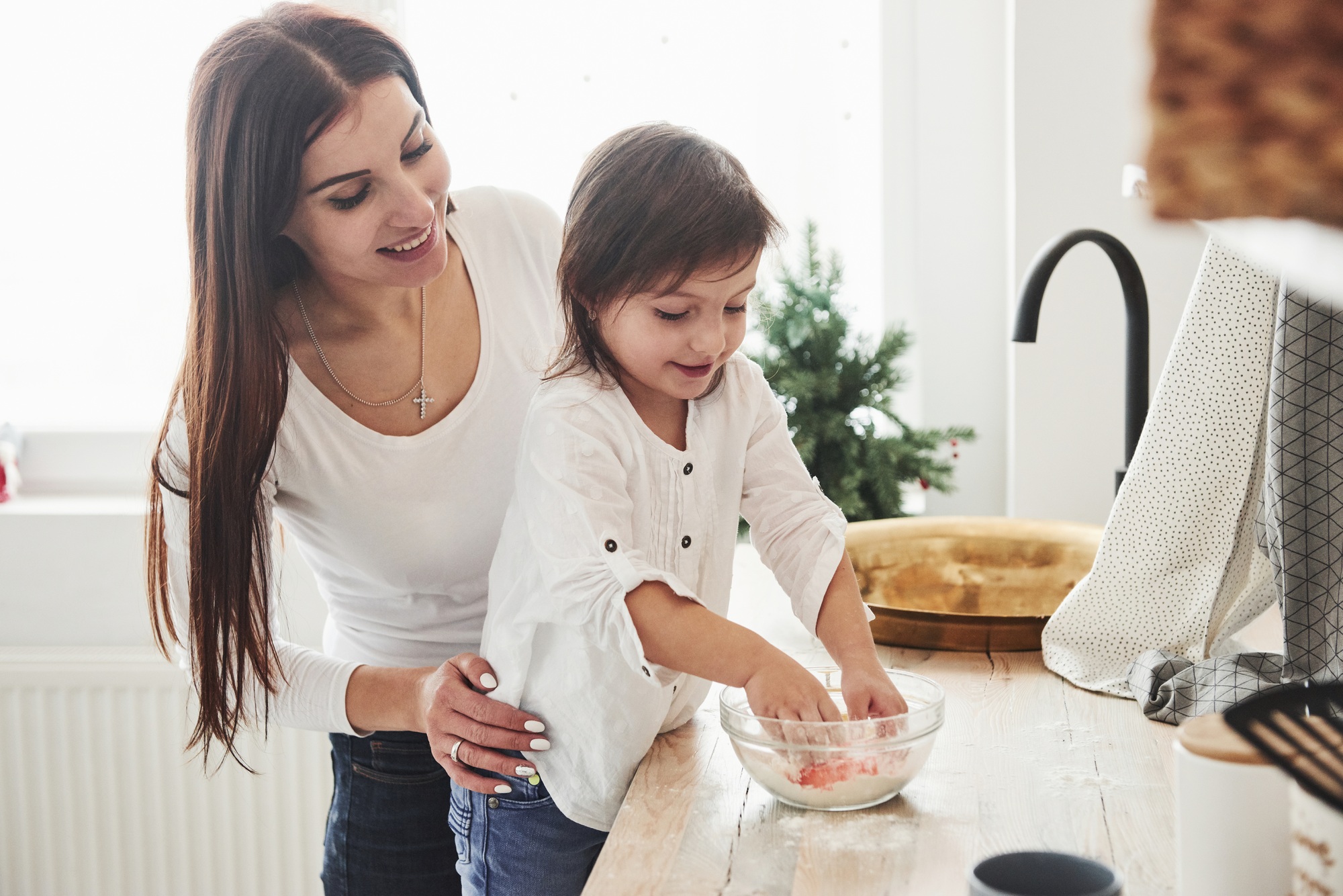 Happy daughter and mom are preparing bakery products together